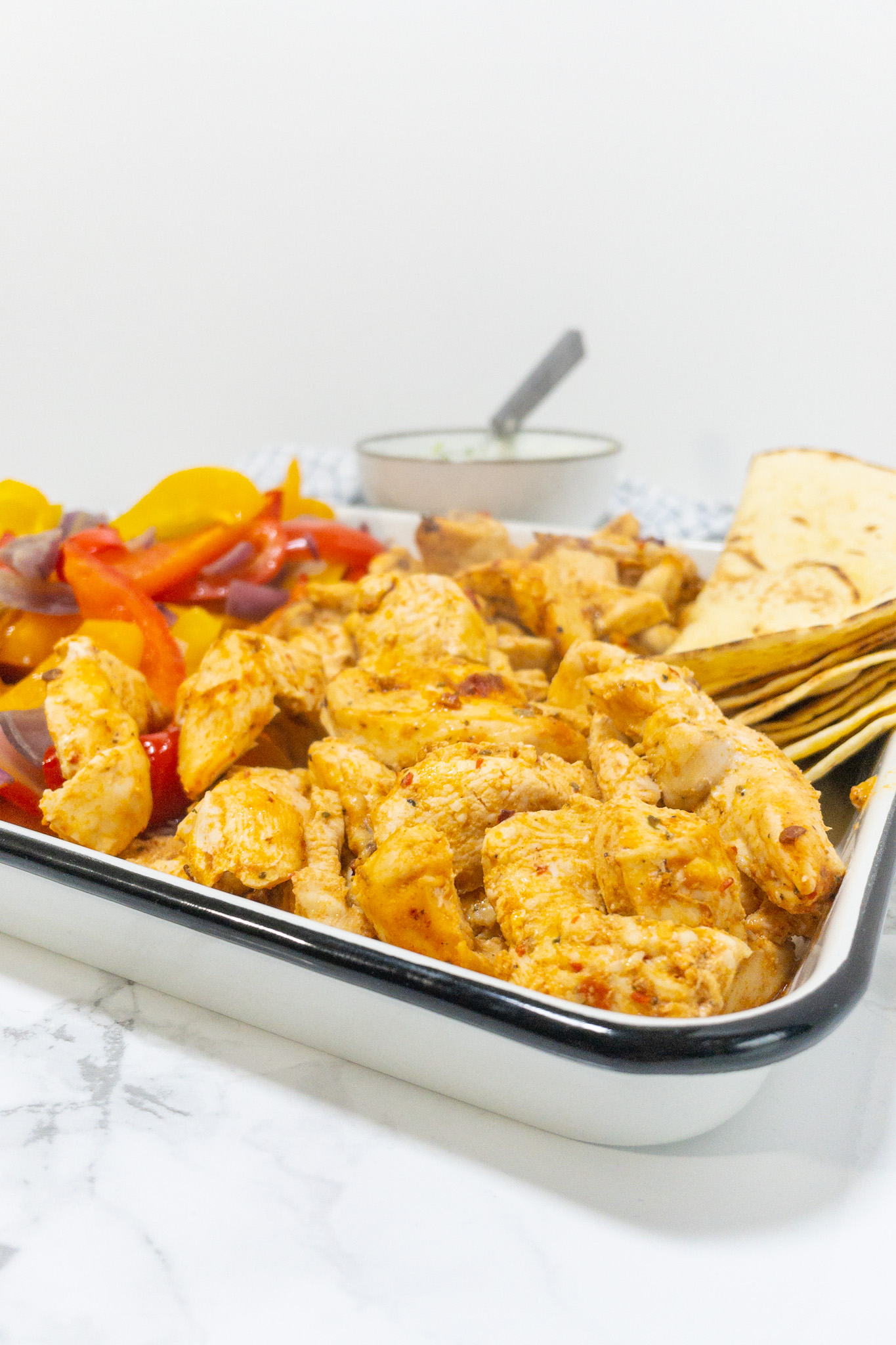 Mexicaans recept voor simpele fajitas, je ziet een ingezoomd beeld van de kip, groenten en tortilla's.